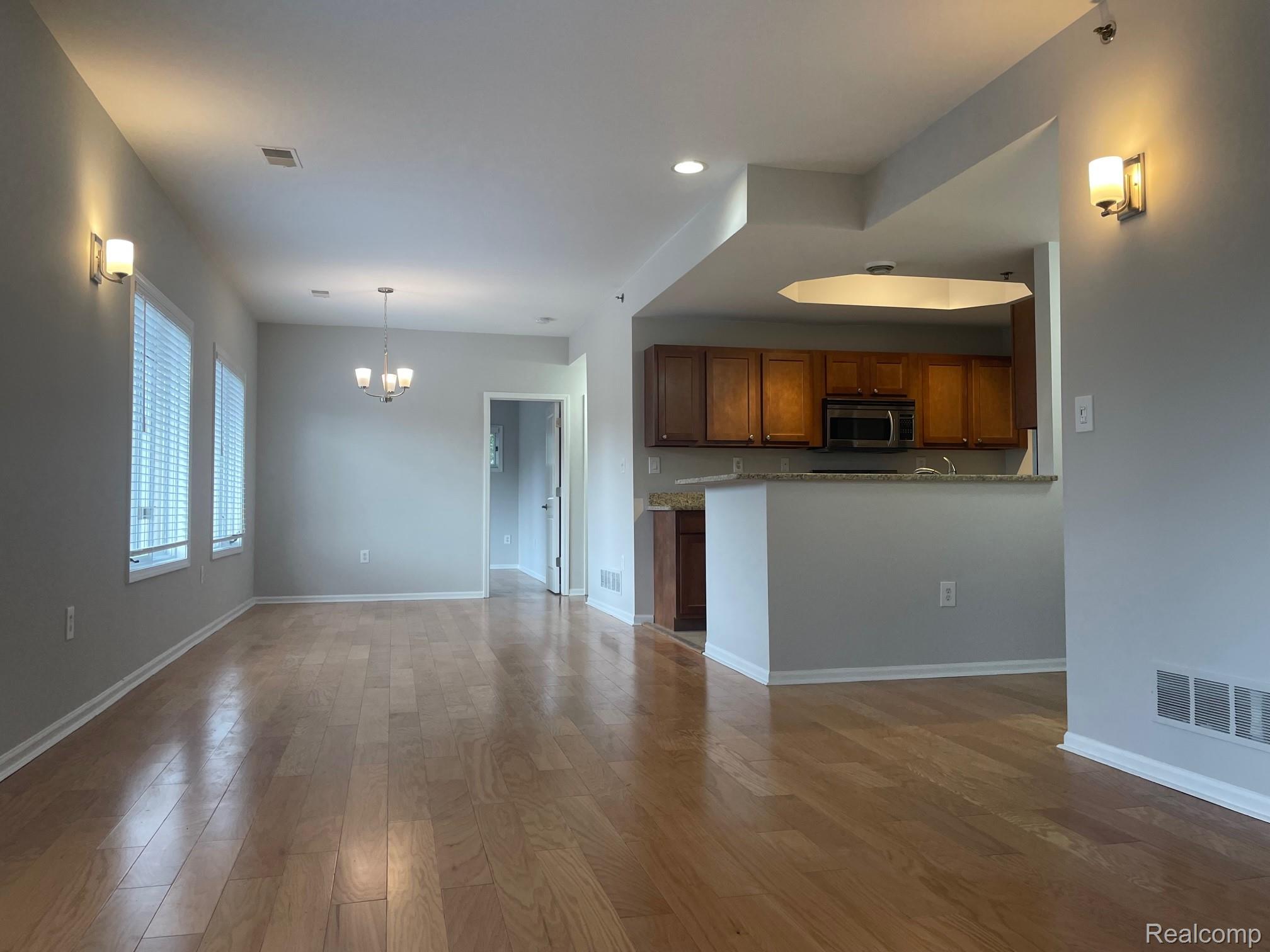 2727 East Maple Road Birmingham, MI 48009 - Photo 17 of 29 Hardwood flooring throughout, recessed lighting, and wall-mounted sconces