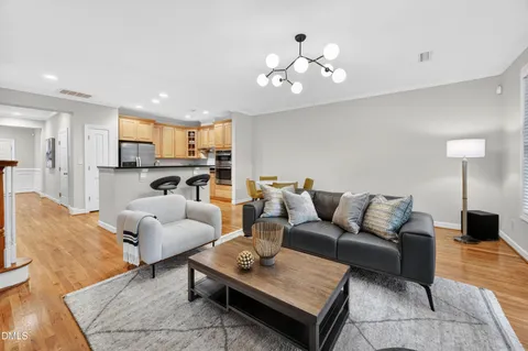 a living room with furniture and a dining table with kitchen view