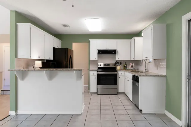a kitchen with stainless steel appliances a stove a sink and a refrigerator