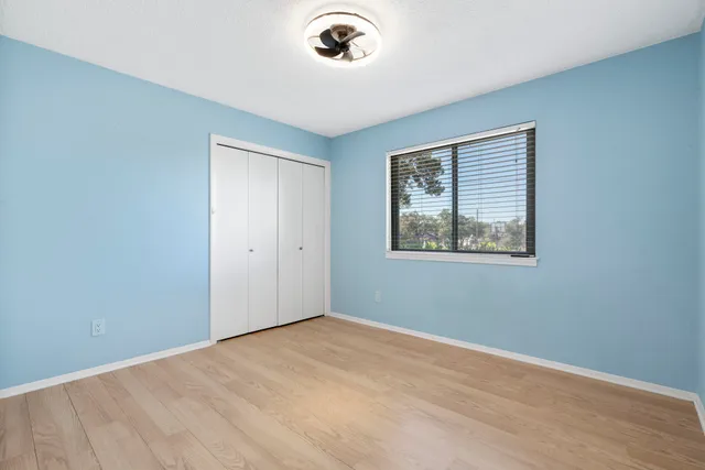an empty room with a window and wooden floor