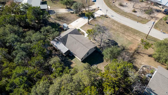 an aerial view of residential houses with outdoor space and trees
