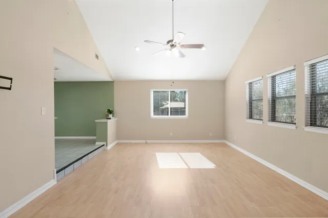 a view of an empty room with a window and cabinet