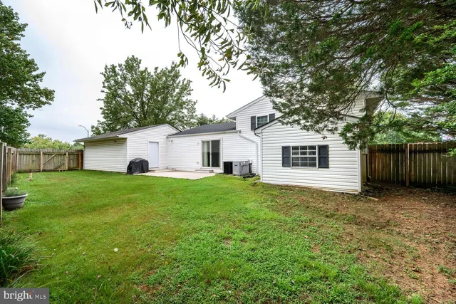 a view of a yard in front of a house with large tree