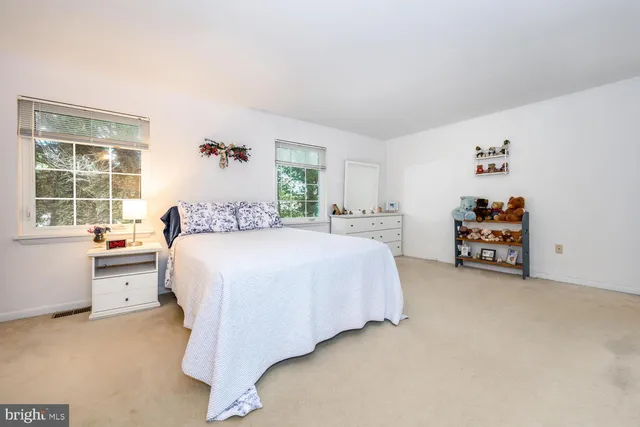 a spacious bedroom with a bed and a large window