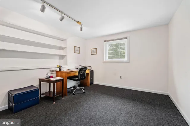 a view of a workspace with furniture and a window