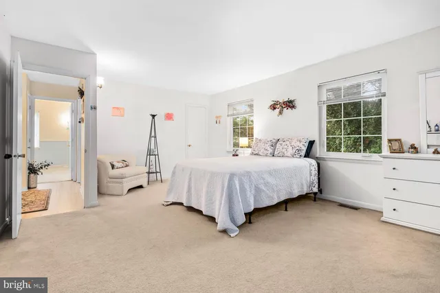 a bedroom with a bed and a large window