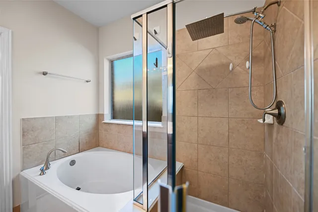 a bathroom with a white bath tub and a shower