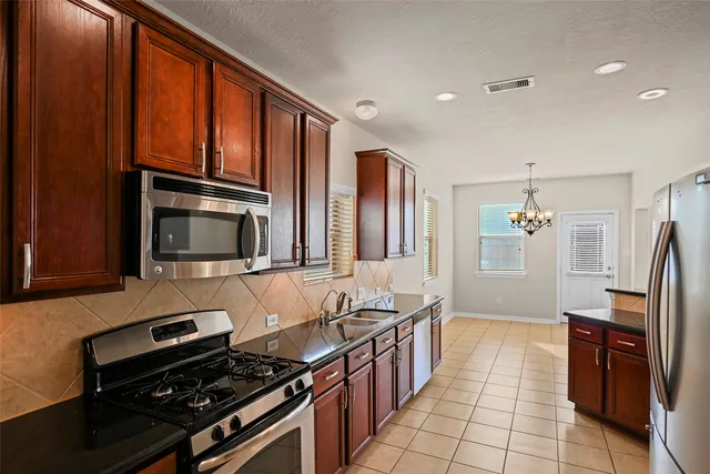 a kitchen with sink refrigerator and stove