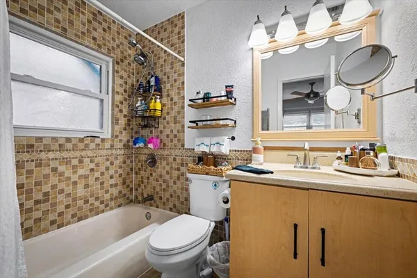 a bathroom with a granite countertop sink a toilet and bathtub
