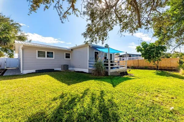 a view of a house with a backyard and a tree