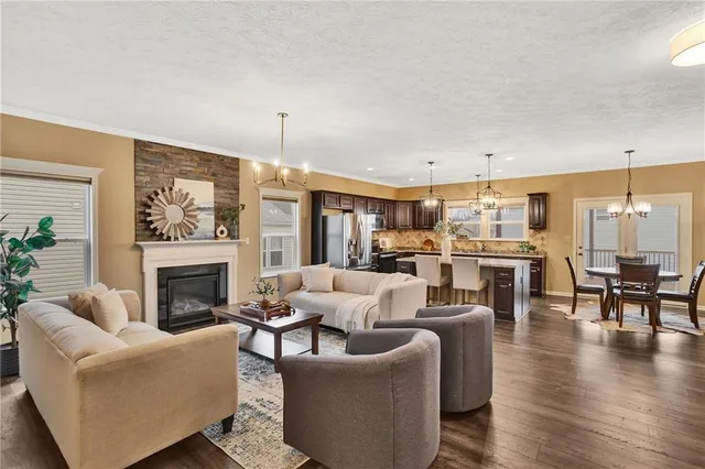 a living room with furniture fireplace and kitchen view