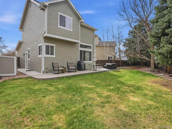 a view of a house with backyard and sitting area