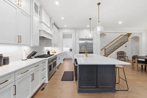 a kitchen with white cabinets and sink