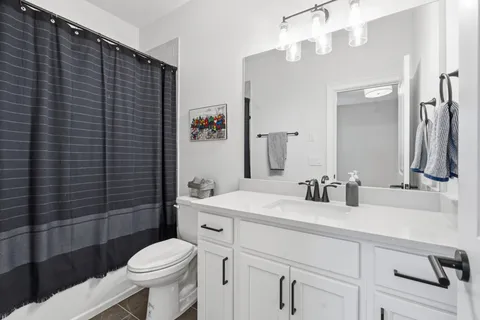 a bathroom with a sink a toilet a mirror and shower