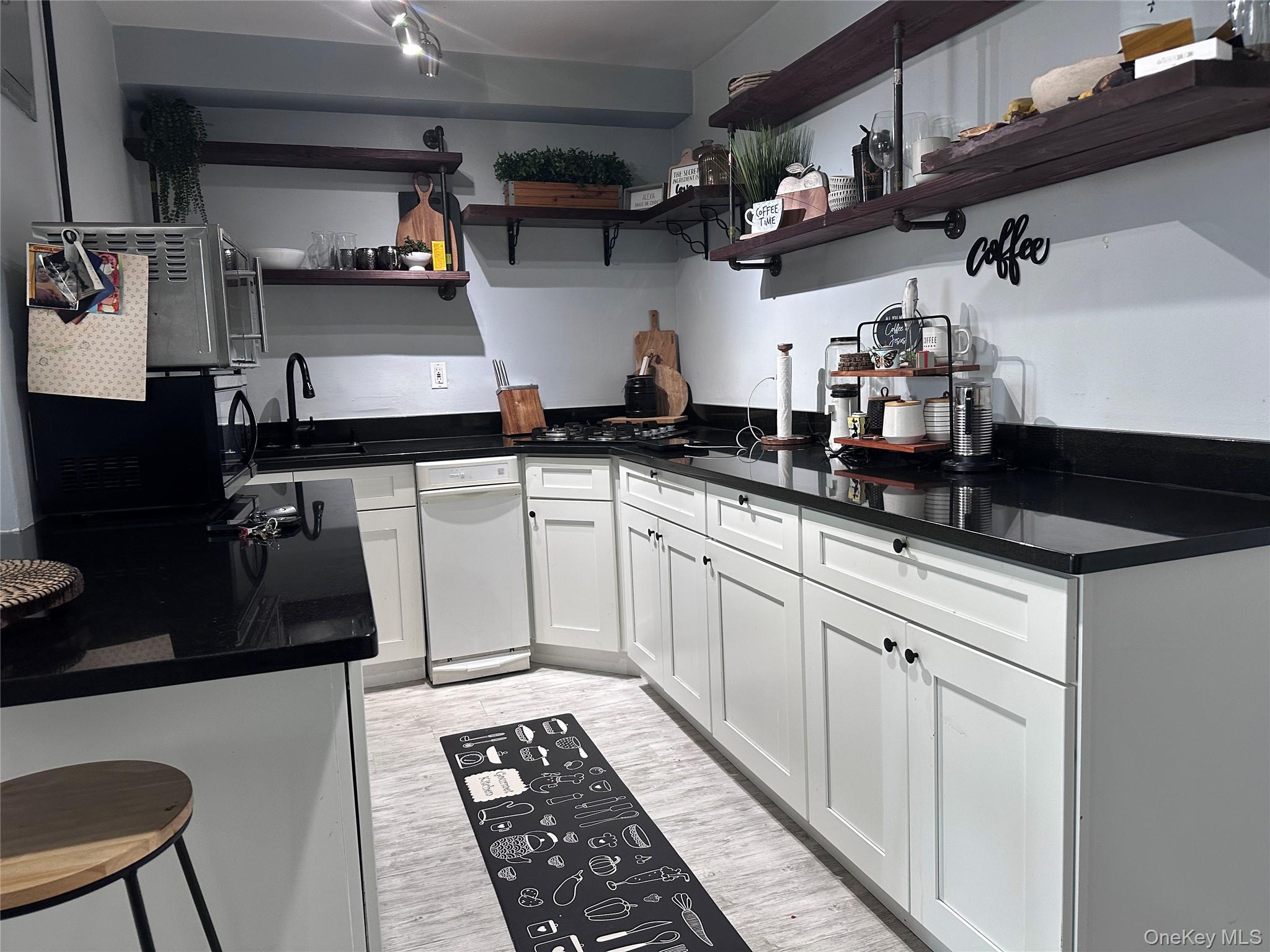 250 West Merrick Road, Unit 2F Freeport, NY 11520 - Photo 4 of 30 a kitchen with stainless steel appliances a sink stove and cabinets