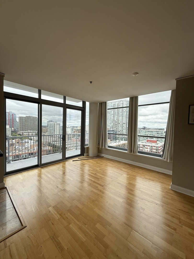 1600 South Prairie Avenue, Unit 1607 Chicago, IL 60616 - Photo 8 of 11 a view of an empty room with wooden floor and a window