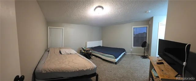 a bedroom with bed and a flat screen tv