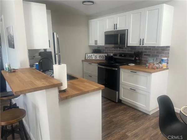 a kitchen with granite countertop a sink appliances and cabinets