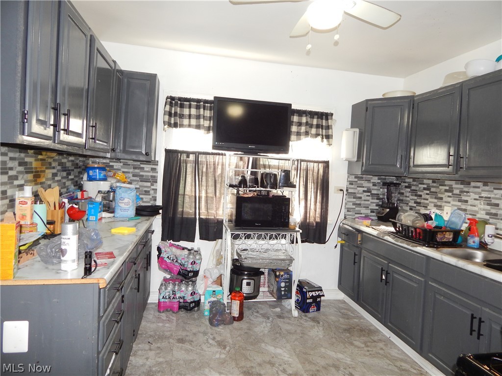 976 Paxton Road Cleveland, OH 44108 - Photo 7 of 22 Kitchen with sink, backsplash, ceiling fan, and light tile floors