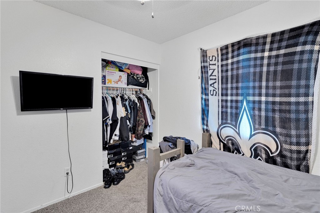 22517 Ojai Road Apple Valley, CA 92308 - Photo 17 of 25 a bed room with a bed and a flat screen tv