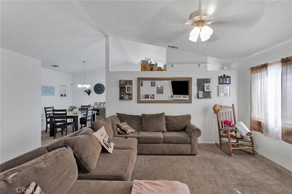 22517 Ojai Road Apple Valley, CA 92308 - Photo 6 of 25 a living room with furniture a flat screen tv and a window