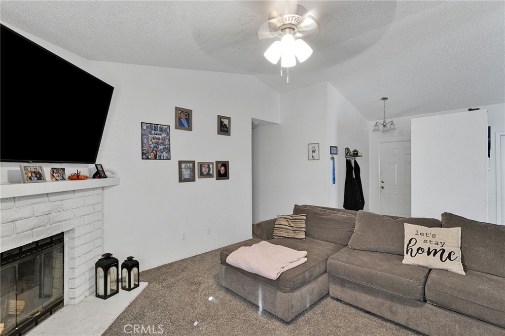 22517 Ojai Road Apple Valley, CA 92308 - Photo 7 of 25 a living room with furniture a flat screen tv and a fireplace