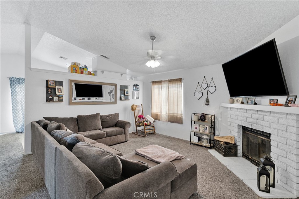 22517 Ojai Road Apple Valley, CA 92308 - Photo 9 of 25 a living room with fireplace furniture and a flat screen tv