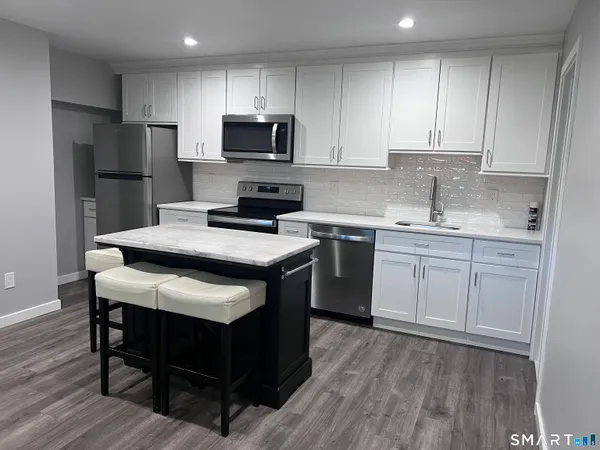 a kitchen with a sink a microwave a refrigerator and cabinets