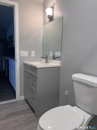 a bathroom with a toilet a sink and mirror