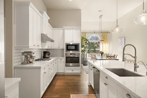 a kitchen with stainless steel appliances granite countertop a sink and oven
