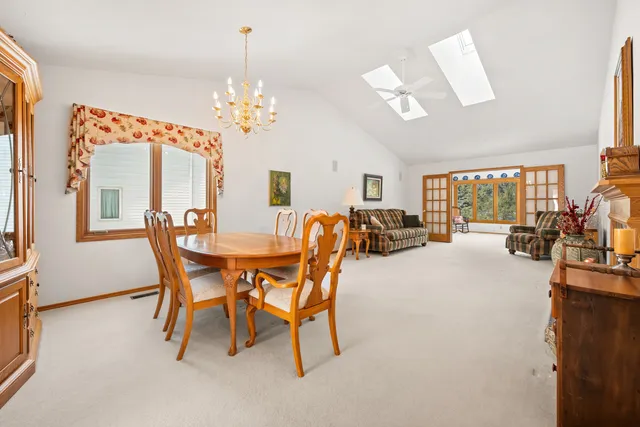 a dining room with furniture a chandelier and window