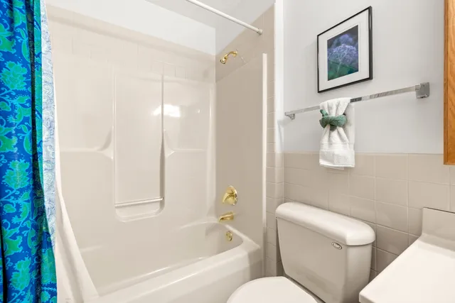 a white toilet sitting next to a bath tub shower