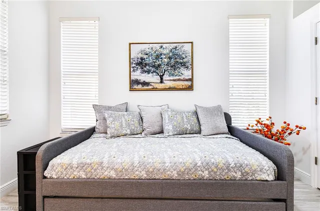 a large bed sitting in a bedroom next to a window and flowers