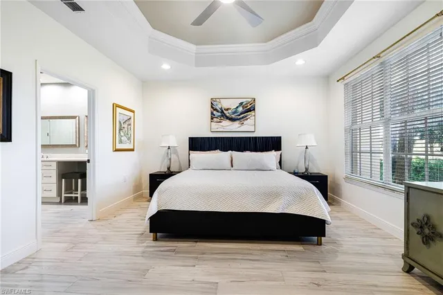 a bedroom with a large bed a fireplace and windows