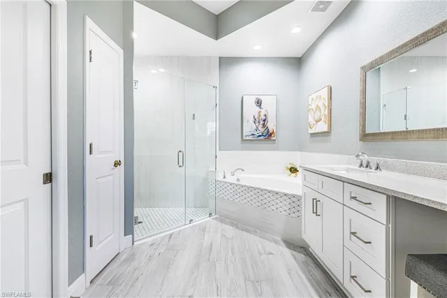 a spacious bathroom with a double vanity sink a mirror and a bathtub