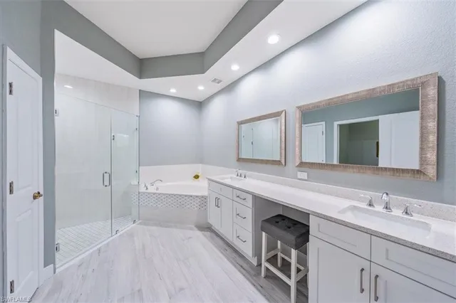 a spacious bathroom with a double vanity sink a mirror and a bathtub
