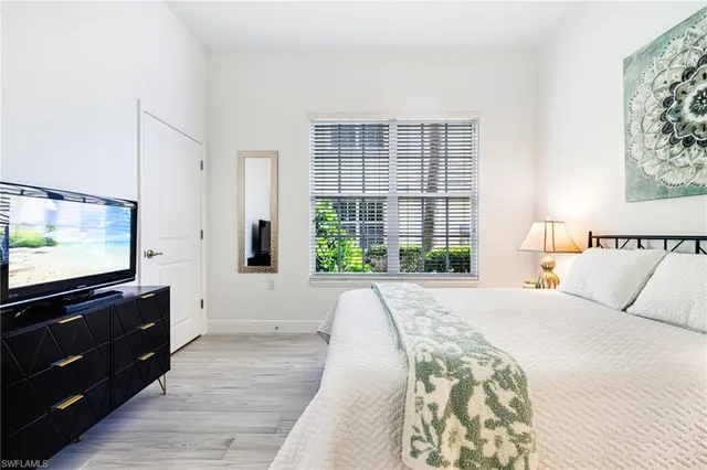 a bedroom with a large bed and a flat screen tv