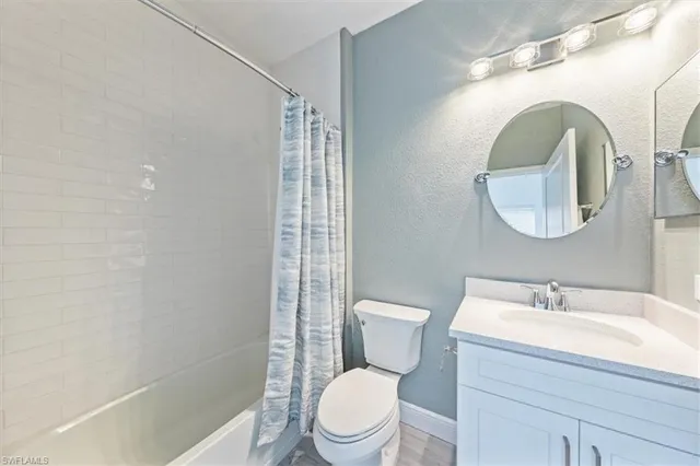 a white toilet sitting next to a bathroom sink and a shower