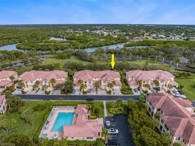 an aerial view of ocean and residential houses with outdoor space