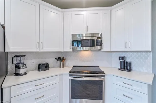 a kitchen with stainless steel appliances granite countertop white cabinets a sink and dishwasher