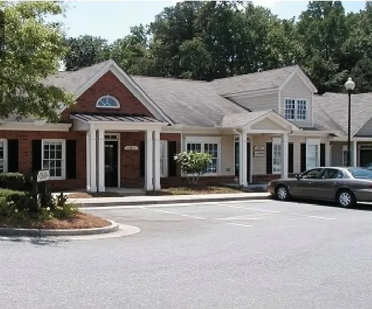 a front view of a house with yard and parking
