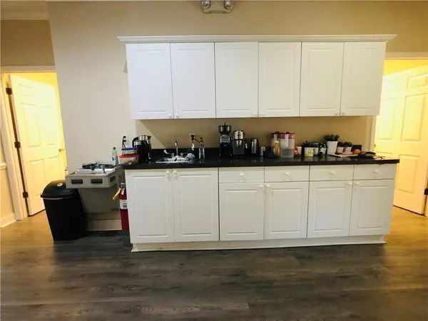 a kitchen with granite countertop a white cabinets and sink