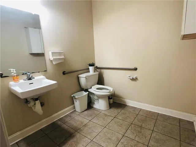 a bathroom with a sink toilet and a mirror