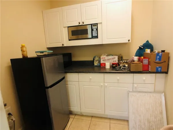 a kitchen with white cabinets and black appliances