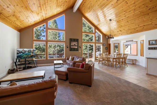 a living room with furniture a table and large windows