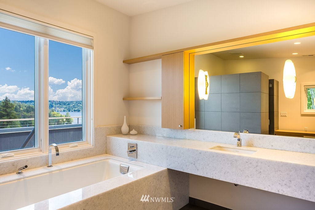 5505 South Upland Road Seattle, WA 98118 - Photo 15 of 32 a bathroom with a tub a sink and a large mirror