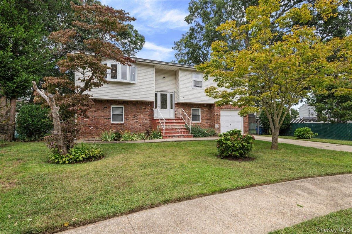 7 Bennett Court Copiague, NY 11726 - Photo 1 of 22 a front view of a house with a garden