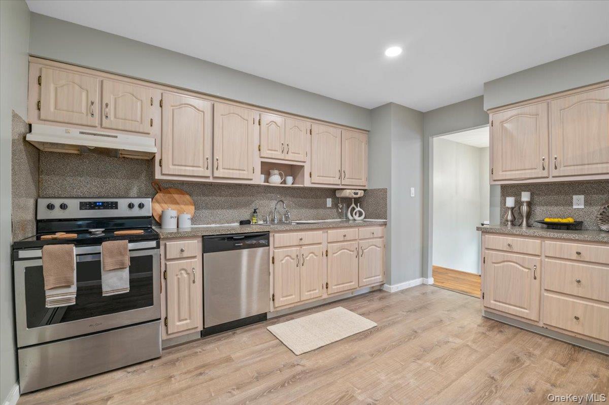 7 Bennett Court Copiague, NY 11726 - Photo 11 of 22 a kitchen with granite countertop white cabinets stainless steel appliances and a sink