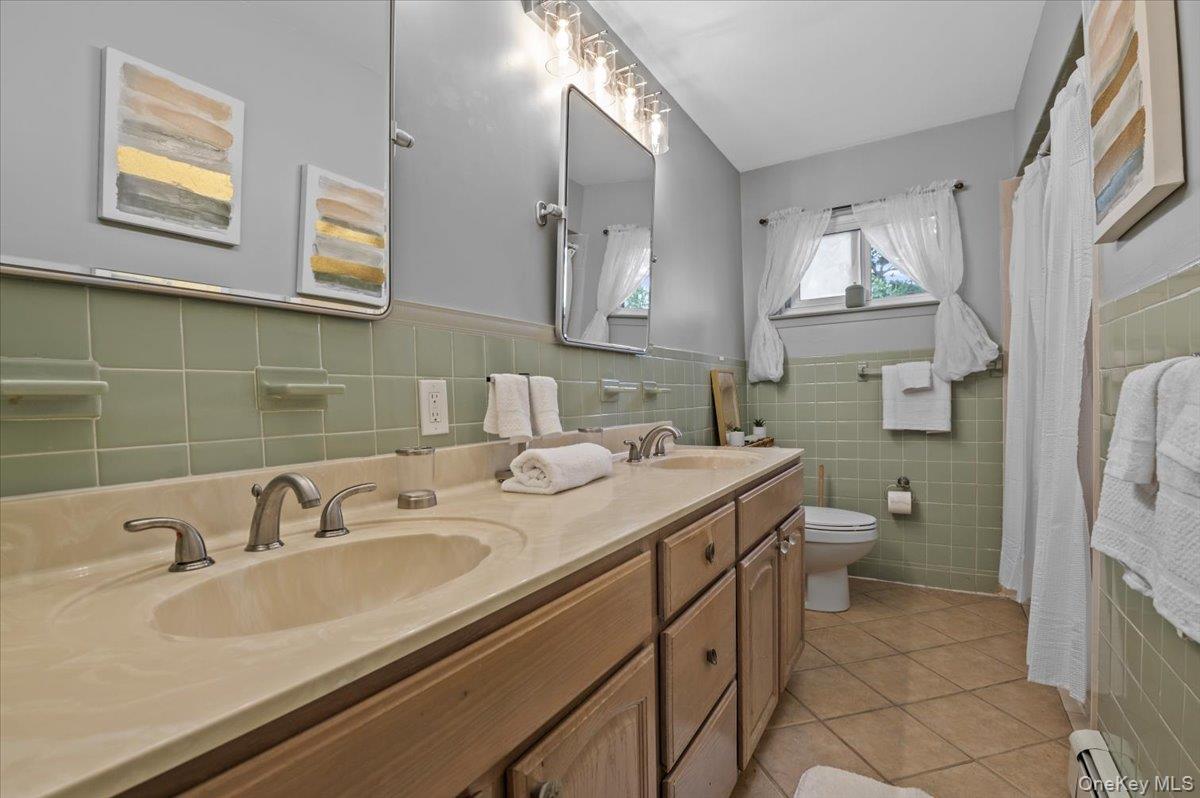 7 Bennett Court Copiague, NY 11726 - Photo 12 of 22 a bathroom with a sink toilet and a mirror