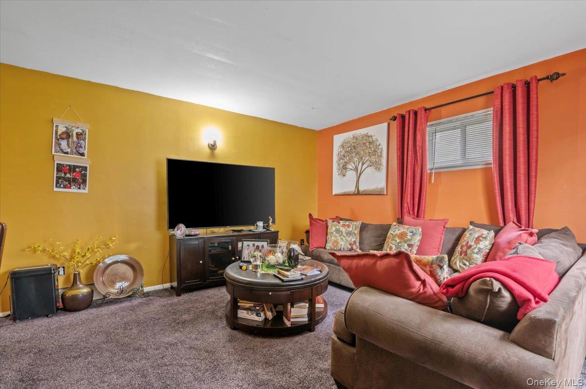 7 Bennett Court Copiague, NY 11726 - Photo 16 of 22 a living room with furniture a flat screen tv and a large window